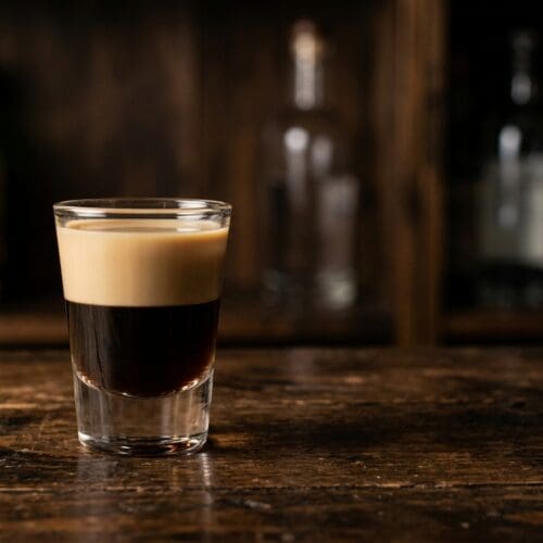 Muddy Water layered shot of coffee liqueur and cream on a dark wooden bar